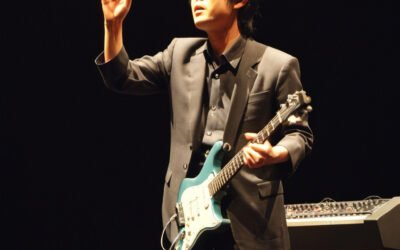 Tatsuro Yamashita performing on stage, symbolizing his impact on city pop and the themes discussed in "Tatsuro Yamashita Blogspot."